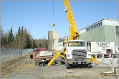 image of crane hoisting a granite monument